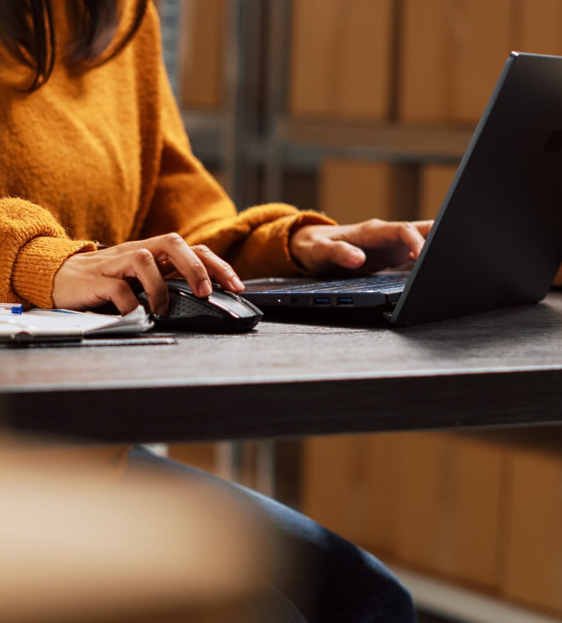 Startup owner working on stock inventory with laptop, planning order distribution for business management in storage room. Worker doing supply chain shipment at desk, retail products. Handheld shot.